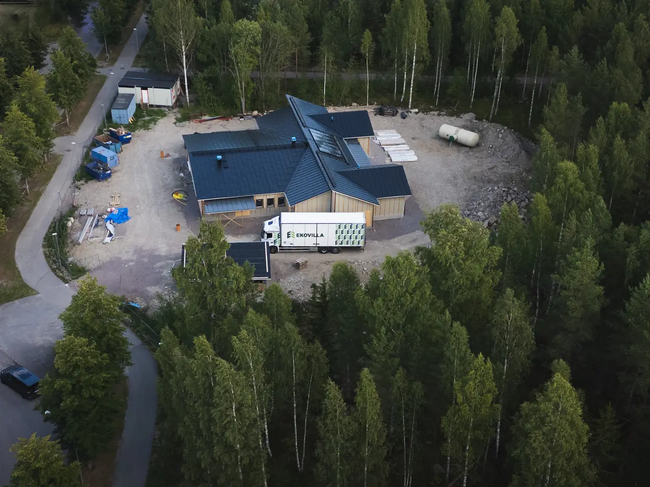 Flygbild över en arbetsplats i skogen där väggar och tak isolerats med lösull